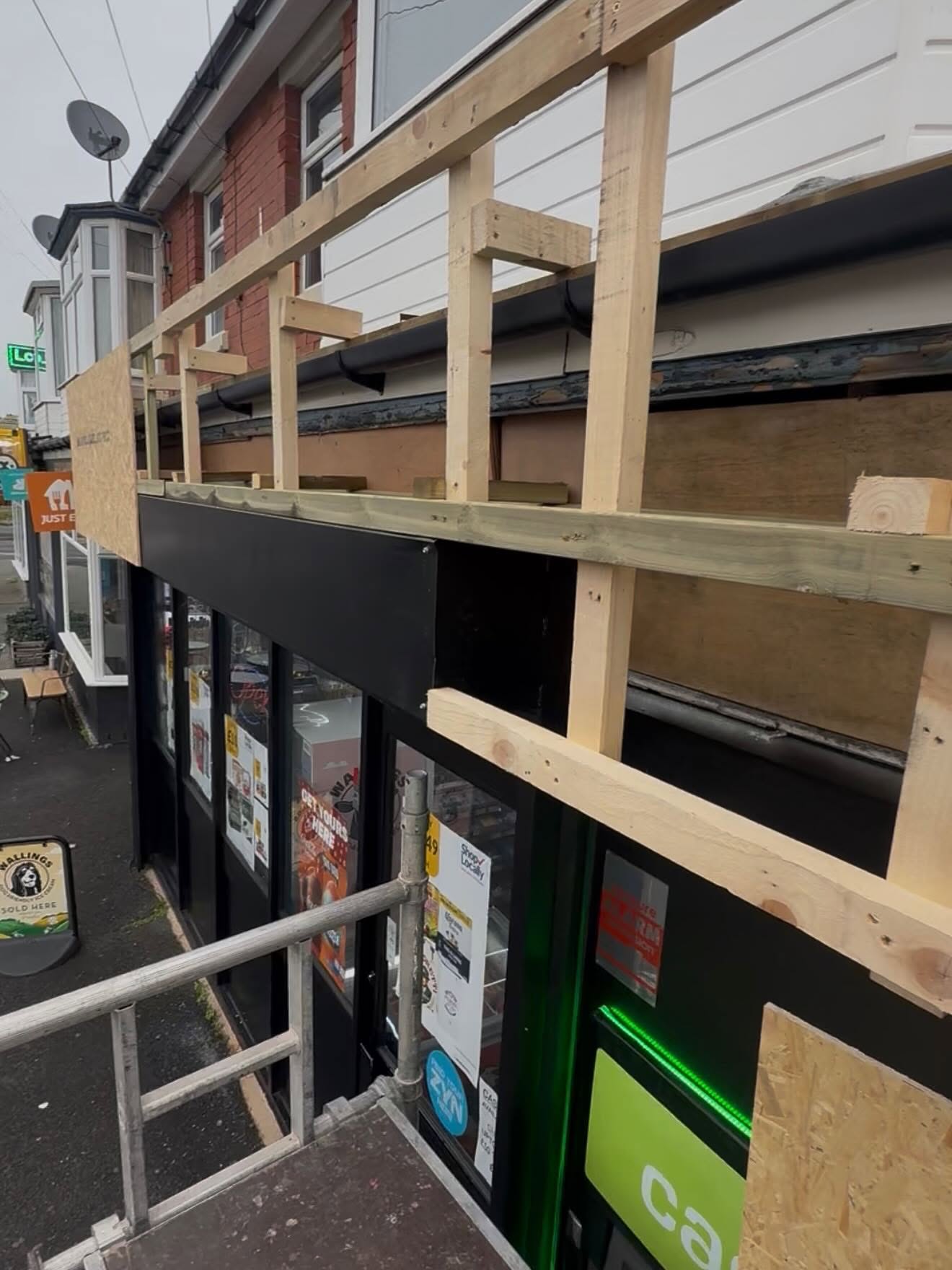 Sign makers at work fitting a shop front sign in Blackpool, Lancashire