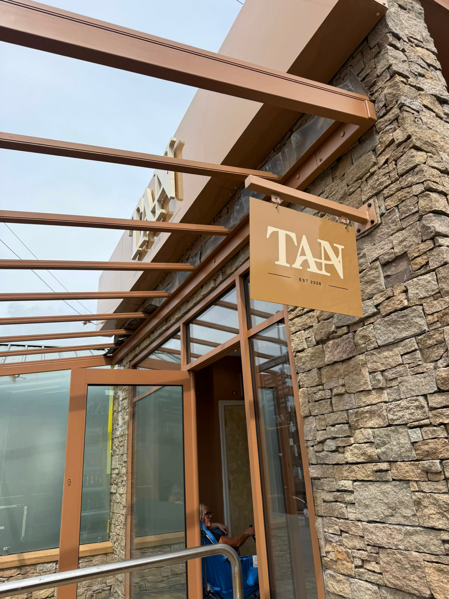 Hanging bracket sign for TAN installed by Ashton Signs